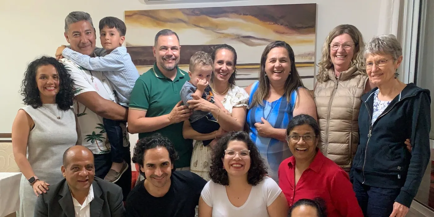 IofC friends from across the Americas gathered in a living room in 2024, two children among them