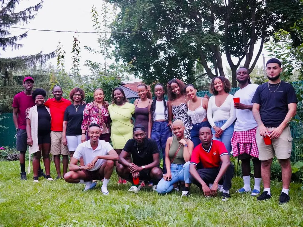 Young adults from the Quebec gathering standing and crouching together on a lawn in summer